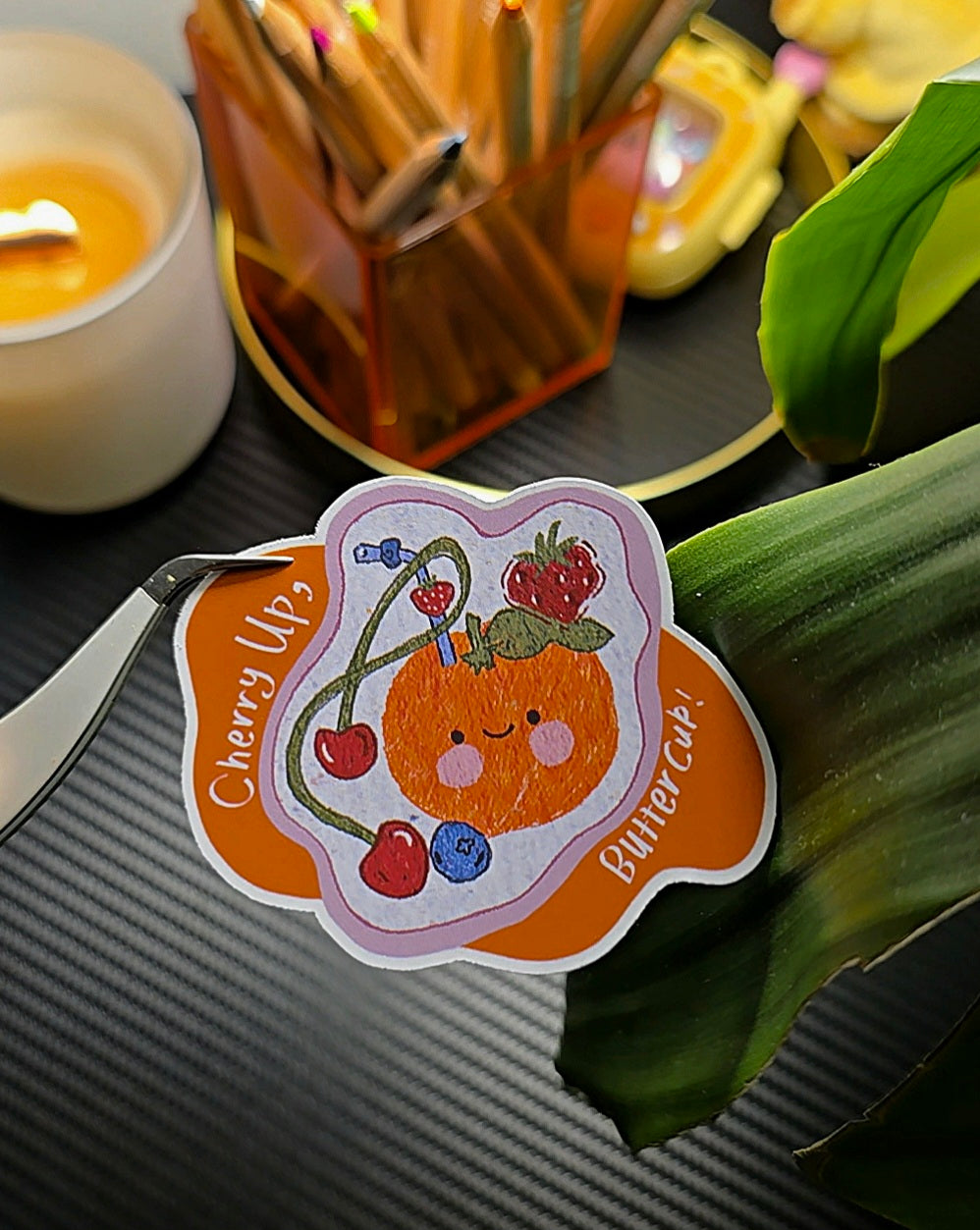 Cherry Up Buttercup matte vinyl die-cut sticker close-up showing kawaii orange character with cherries, strawberries and blueberries