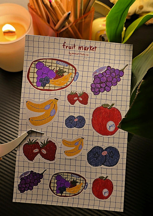 Fruit Market sticker sheet close-up showing die-cut stickers of grapes, bananas, strawberries, blueberries and apple on grid background