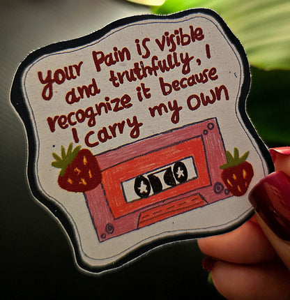 Sticker with a cassette tape design and text held by a hand