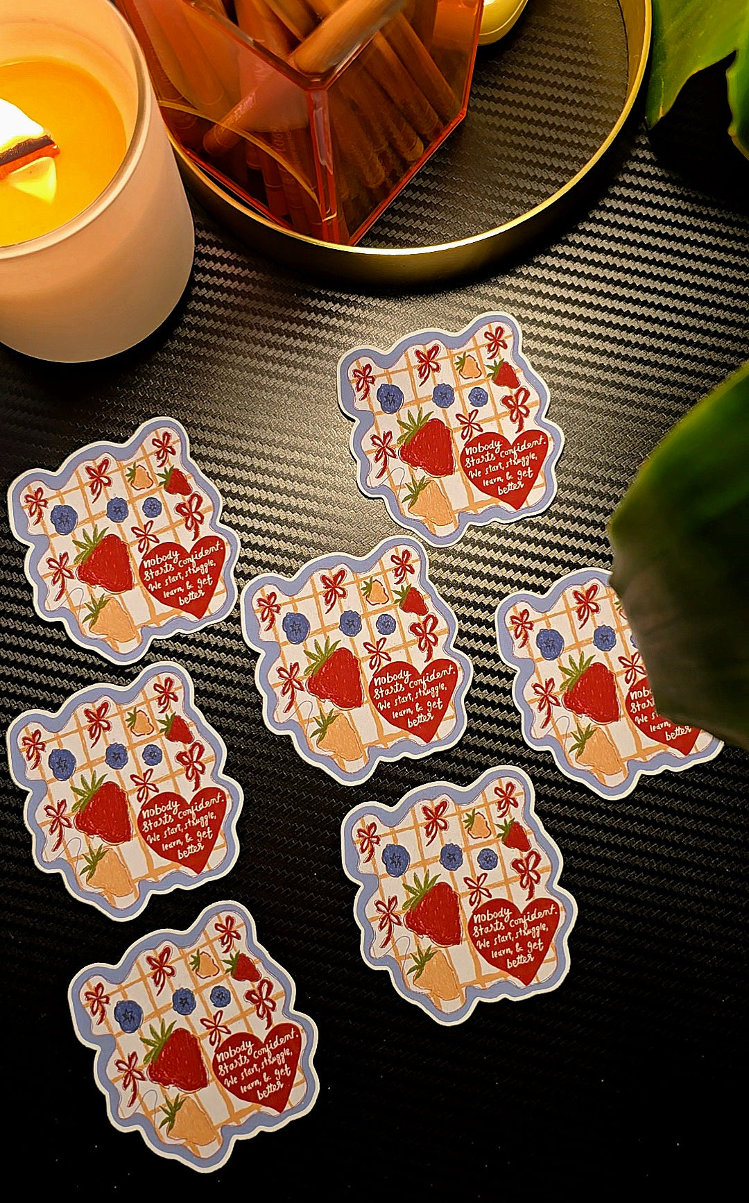 Nobody Starts Confident matte vinyl die-cut sticker close-up showing strawberries, blueberries, bows and motivational quote on heart