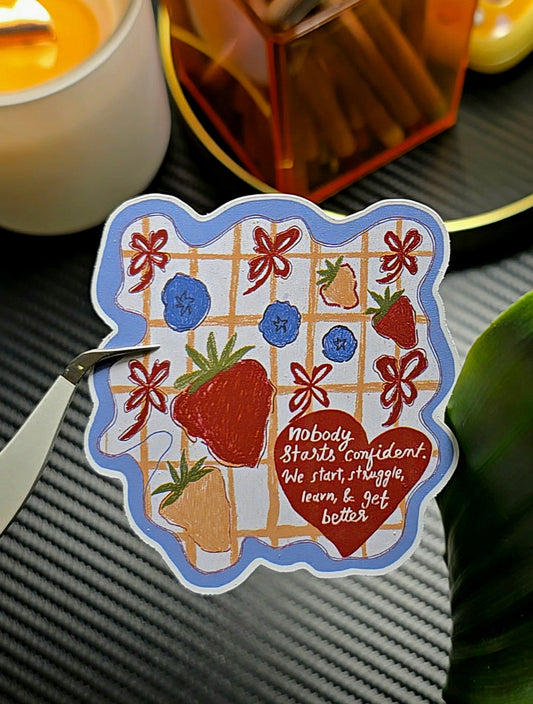 Nobody Starts Confident matte vinyl die-cut sticker with strawberries, blueberries, bows and plaid background – group photo