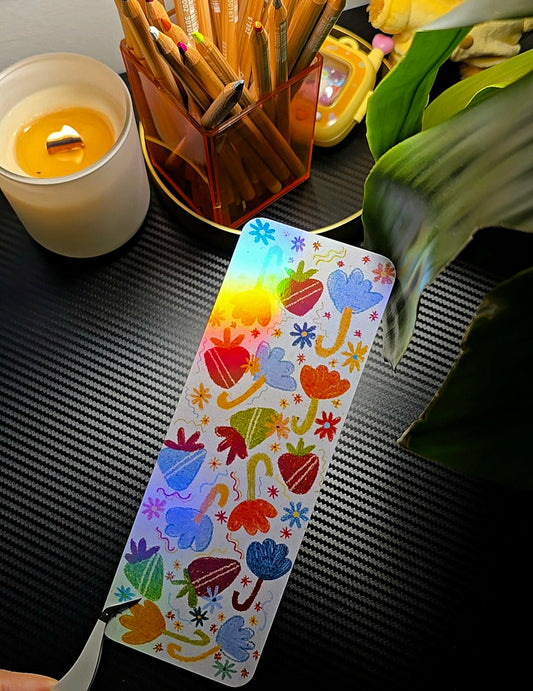 Strawberry Umbrella holographic bookmark flat lay showing colourful folk-art strawberries, umbrellas and flowers on sparkly holographic background